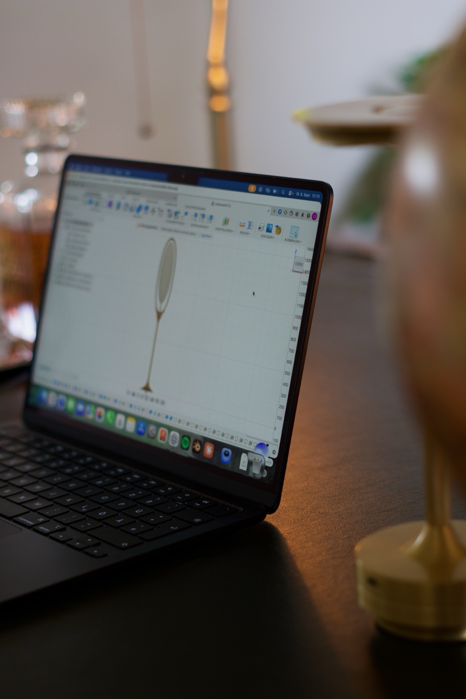 Laptop mit dem digitalen Leuchtenentwurf auf einem Tisch neben einer Leuchte