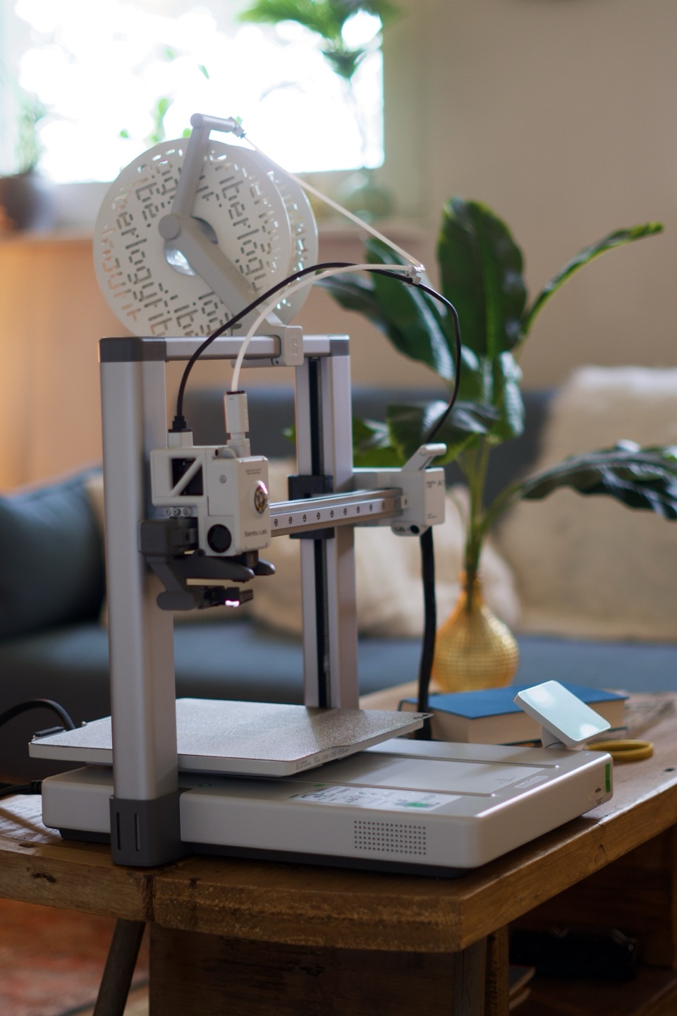 Bambu Lab A1 3D-Drucker mit Filamentrolle und Bauplattform im Atelier